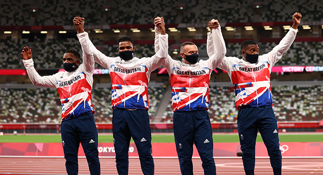 Tokyo 2020 Olympics - Athletics - Men's 4 x 100m Relay - Medal Ceremony - Olympic Stadium, Tokyo, Japan - August 7, 2021. Silver medallists Chijindu Ujah of Britain, Zharnel Hughes of Britain, Richard Kilty of Britain and Nethaneel Mitchell-Blake of Britain celebrate on the podium as they all wear protective face masks REUTERS/Andrew Boyers