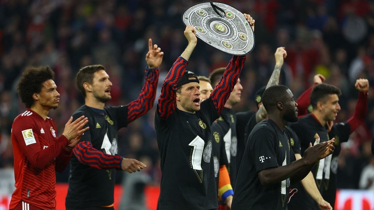 Soccer Football - Bundesliga - Bayern Munich v Borussia Dortmund - Allianz Arena, Munich, Germany - April 23, 2022 Bayern Munich's Thomas Muller celebrates with a replica trophy and teammates after winning the Bundesliga REUTERS/Kai Pfaffenbach DFL REGULATIONS PROHIBIT ANY USE OF PHOTOGRAPHS AS IMAGE SEQUENCES AND/OR QUASI-VIDEO.