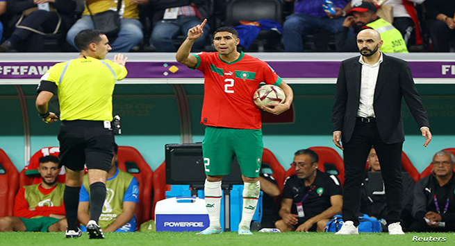 Soccer Football - FIFA World Cup Qatar 2022 - Semi Final - France v Morocco - Al Bayt Stadium, Al Khor, Qatar - December 14, 2022 Morocco's Achraf Hakimi prepares to take a throw-in as coach Walid Regragui looks on REUTERS/Molly Darlington