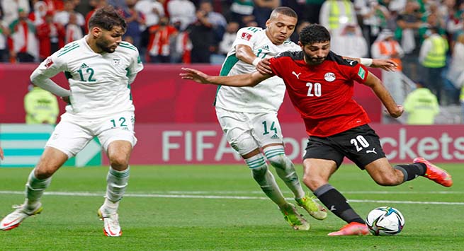 Egypt's forward Hussein Faisal (R) attempts a shot as he is marked by Algeria's defender Mohamed Tougai (L) during the FIFA Arab Cup 2021 group D football match between Algeria and Egypt at the Al-Janoub Stadium in the Qatari city of Al-Wakrah on December 7, 2021. (Photo by Khaled DESOUKI / AFP)