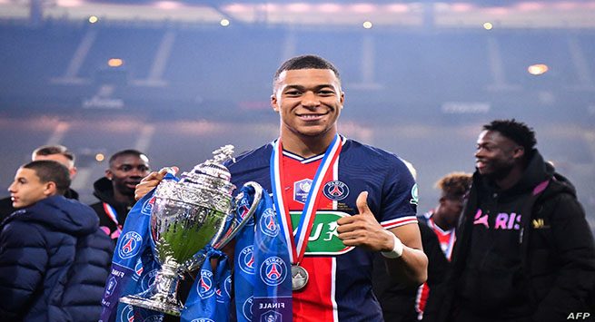 Paris Saint-Germain's French forward Kylian Mbappe celebrates with the trophy after winning the French Cup final football match between Paris Saint-Germain and Monaco at the Stade de France stadium, in Saint-Denis, on the outskirts of Paris, on May 19, 2021. (Photo by FRANCK FIFE / AFP)